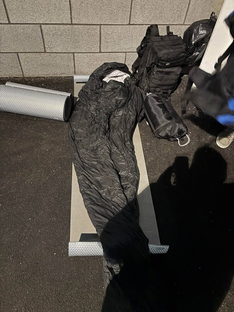 A sleeping bag and mat laid out on the ground for the night